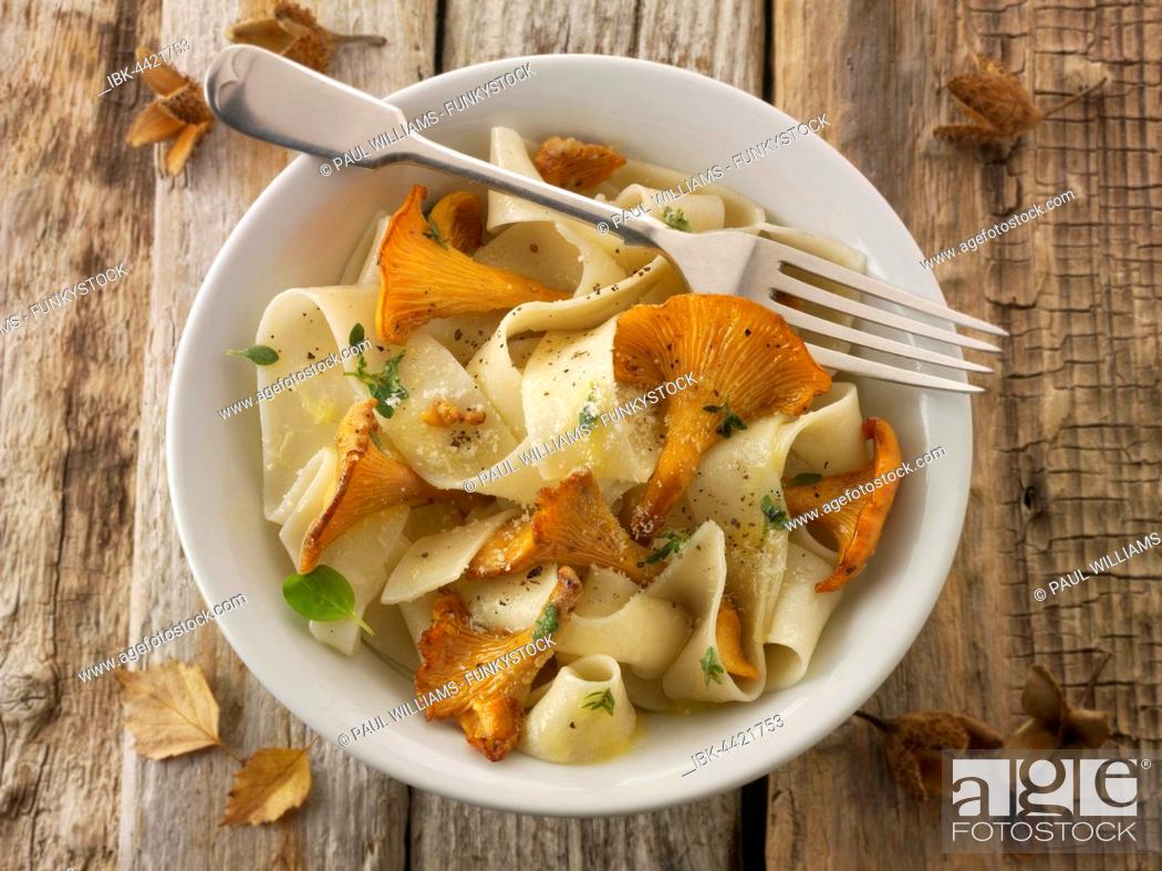 Stock Photo: Wild organic chanterelle or girolle Mushrooms (Cantharellus cibarius) sauted in butter on Pappardelle pasta.