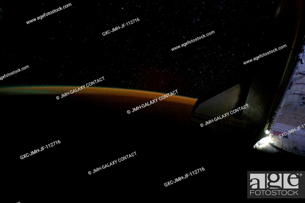 Stock Photo: Earth's thin line of atmosphere and a starry sky just off the port wing of the docked space shuttle Endeavour are featured in this image photographed by NASA.