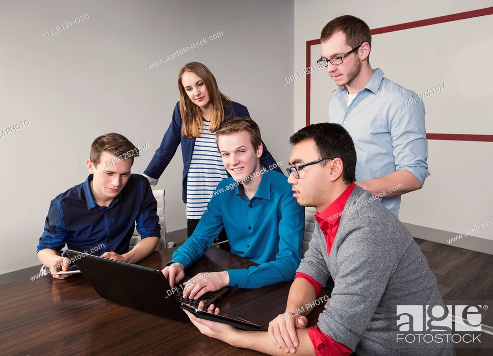 Imagen: Young millennial business professionals working together in a conference room in a high tech modern business; Sherwood Park, Alberta, Canada.
