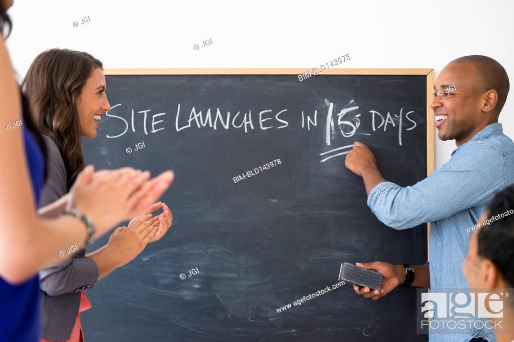 Stock Photo: Business people cheering and gearing up for site launch in office.