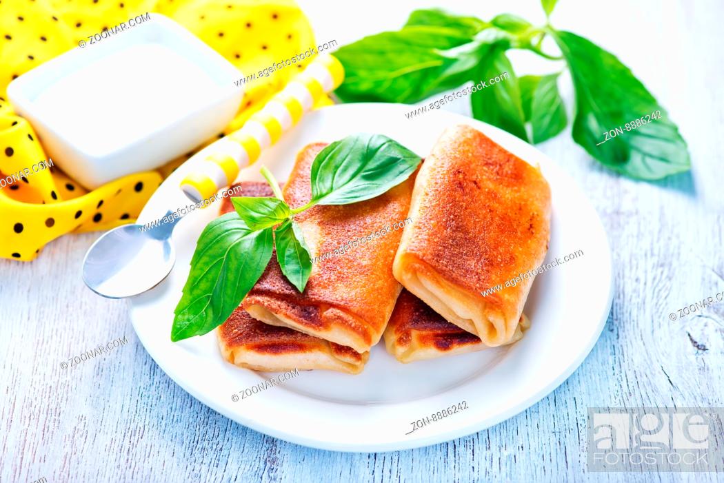 Stock Photo: pancakes with meat and fresh basil on the plate.