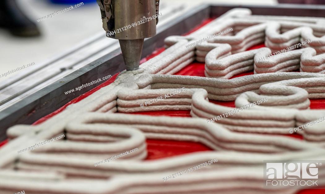 Stock Photo: 10 December 2021, Saxony, Chemnitz: A robot 3D prints a fibre-reinforced concrete arch in a research hall at TU Chemnitz.