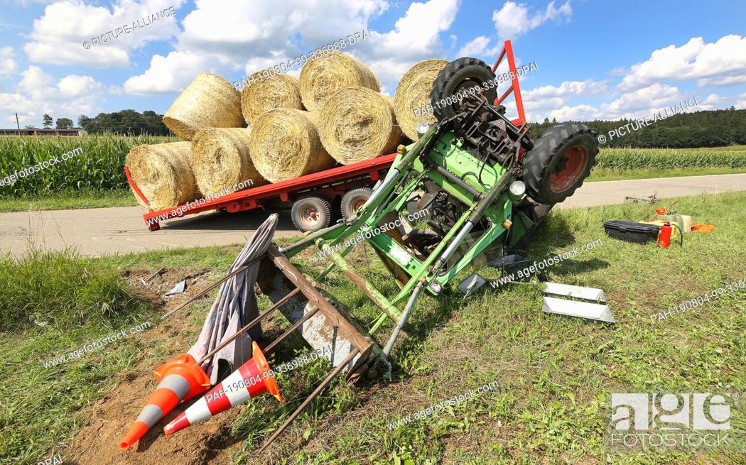 Stock Photo: 04 August 2019, Baden-Wuerttemberg, Pfronstetten-Aichstetten: A tractor lies beside a road. Two children were injured in a tractor accident in Pfronstetten.