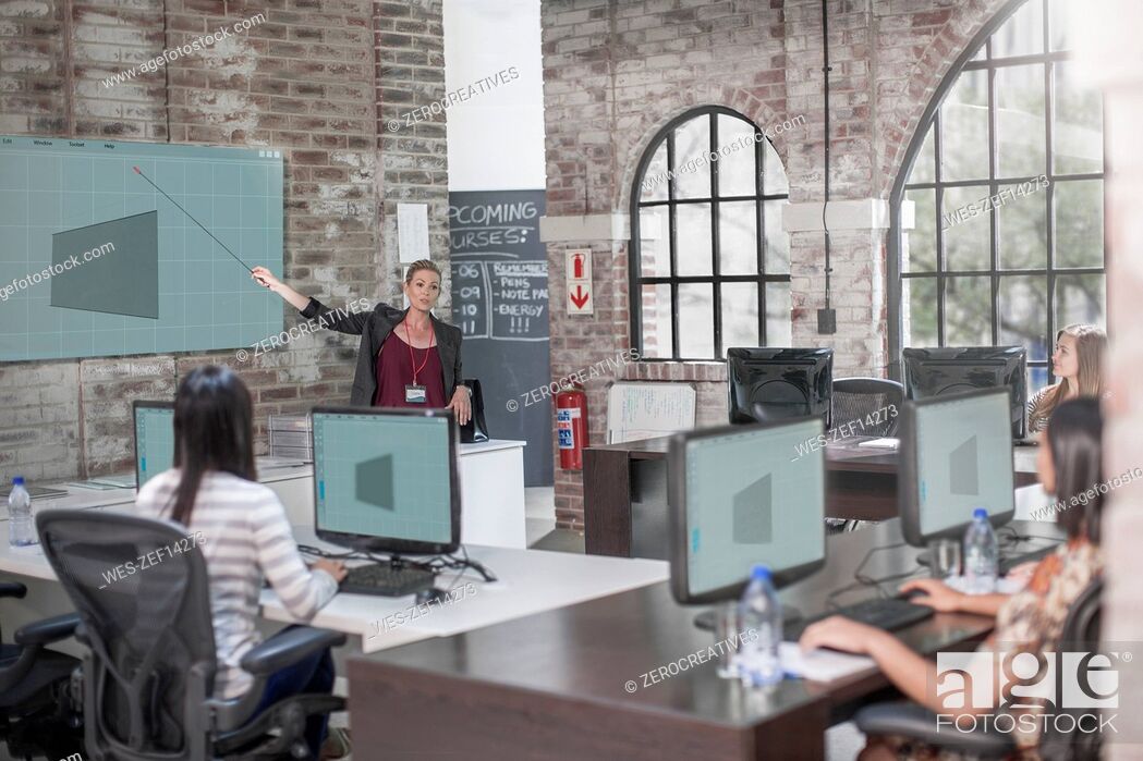 Stock Photo: Adult Education, students receiving lesson at computer training centre.