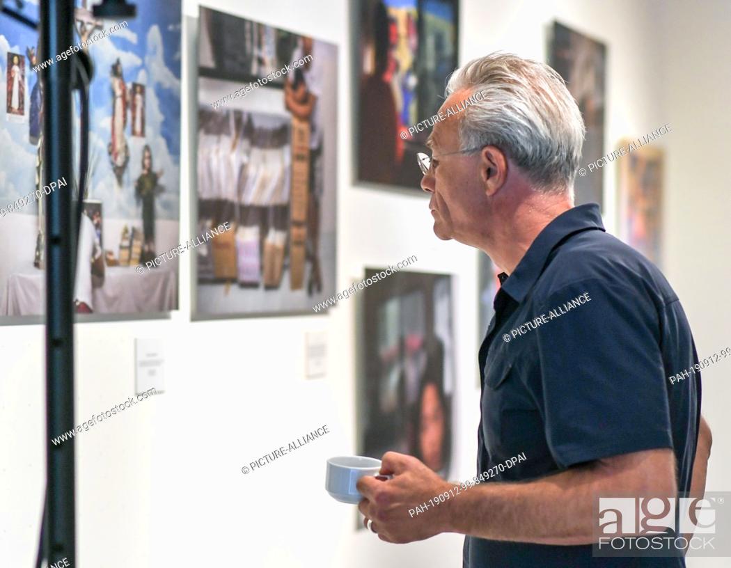 Stock Photo: 11 September 2019, Berlin: The crime scene actor Klaus J. Behrendt looks at the pictures in the photo exhibition ""Children behind bars"" in the Mensing Gallery.