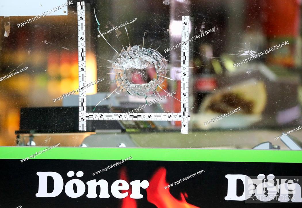 Stock Photo: 10 October 2019, Saxony-Anhalt, Halle: Police markings stick around a bullet in the window of a kebab shop. During attacks in the middle of Halle an der Saale.