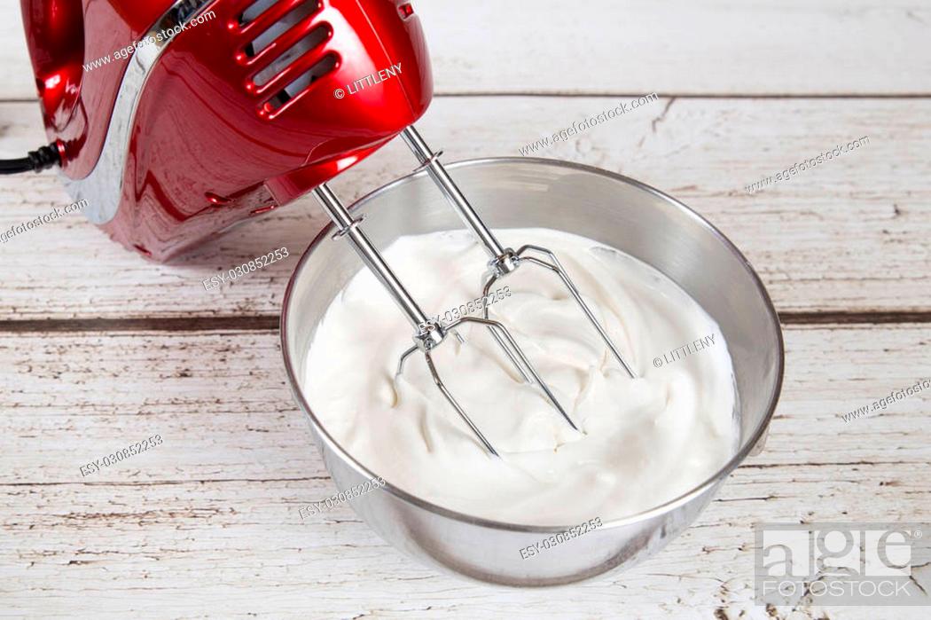 Stock Photo: Electric hand mixer with whipped cream.