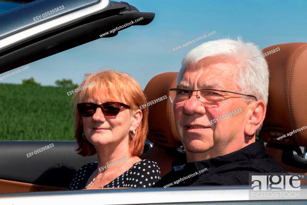 Stock Photo: Smiling happy senior couple in sports car.