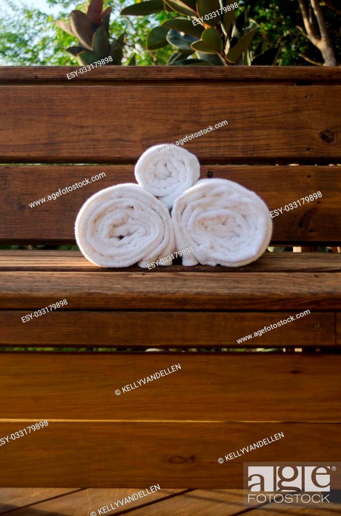 Stock Photo: Towels sit on a wooden bench offering vacationers a spa like setting for rest and relaxation.