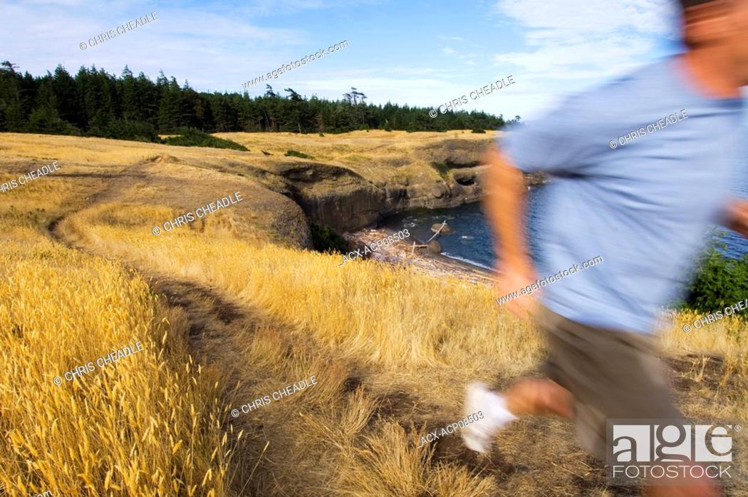 Stock Photo: Blurred runner on trail, Hornby Island at Helliwell Park, Gulf Islands British Columbia, Canada.