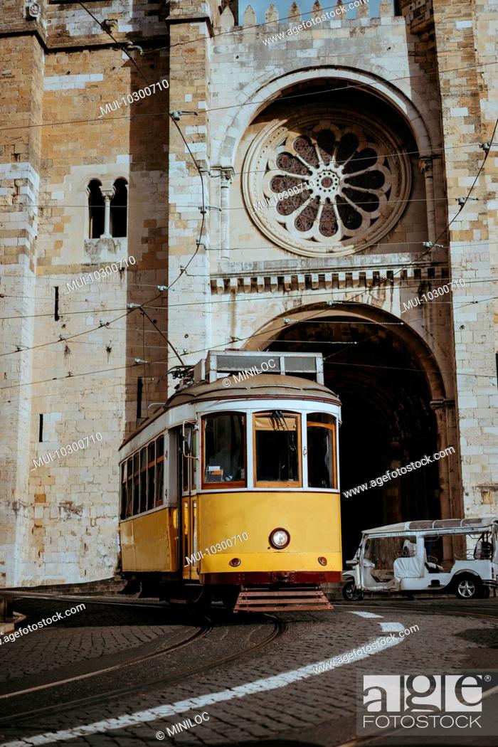 Stock Photo: Quaint yellow tram passes directly in front of the Se Cathedral in Lisbon, Lisboa, Lissabon, Portugal, Europe.