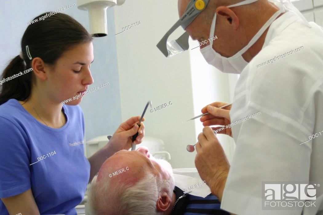 Stock Photo: Dentist controls tartar with assistant at the patient.