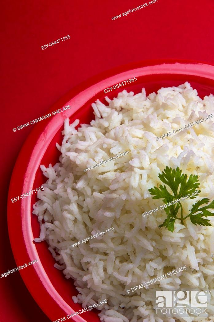 Stock Photo: Cooked plain white basmati rice in a red plate on red background.