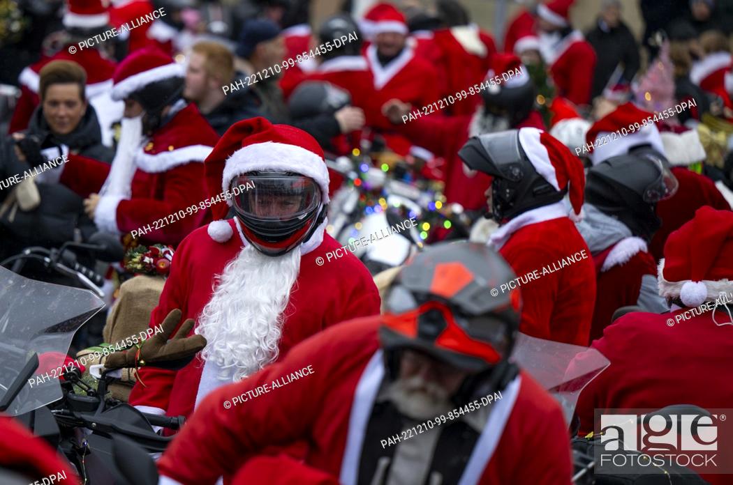 Stock Photo: 10 December 2022, Berlin: Participants in the ""Santa Claus on Road"" campaign sit on their Christmas-decorated motorcycles shortly before setting off.