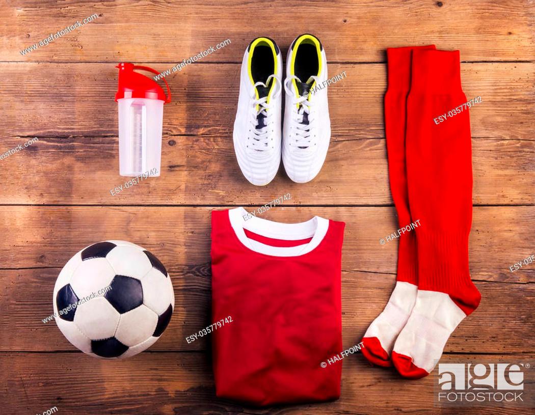 Photo de stock: Various football stuff lined up on a wooden floor background.
