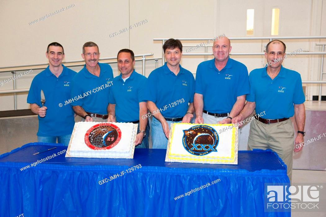 Stock Photo: Expedition 2930 crew members pose for a photo during a cake-cutting ceremony in the Jake Garn Simulation and Training Facility at NASA's Johnson Space Center.