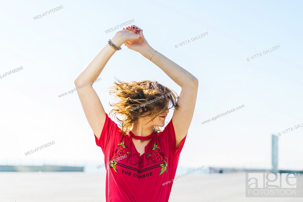 Stock Photo: Happy young woman outdoors shaking her hair.