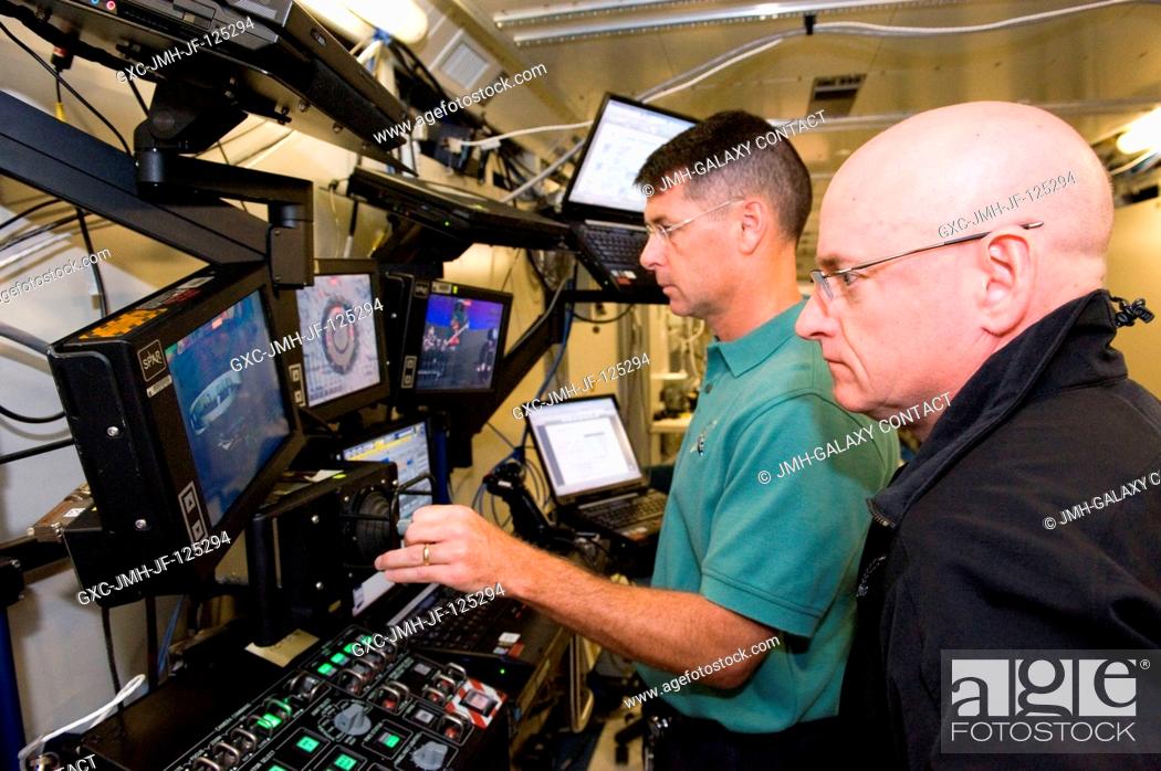 Stock Photo: NASA astronaut Scott Kelly (foreground), Expedition 25 flight engineer and Expedition 26 commander, and NASA astronaut Shane Kimbrough participate in a robotics.