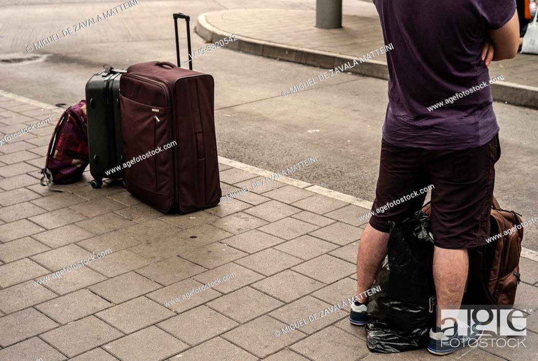 Stock Photo: Man waiting for his bus with suitcases in Hamburg, Germany.