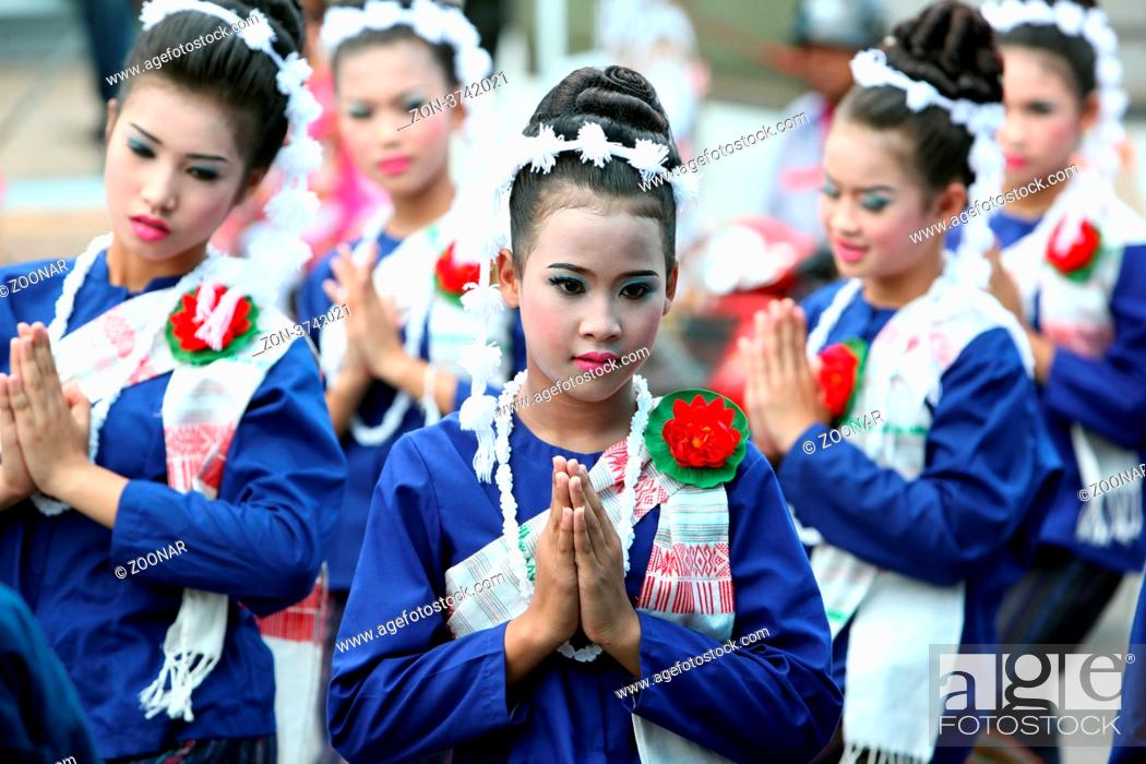 Stock Photo: Eine traditionelle Tanzgruppe mit der thailaendischen Begruessung zeigt sich an der Festparade beim Bun Bang Fai oder Rocket Festival in Yasothon im Isan im.