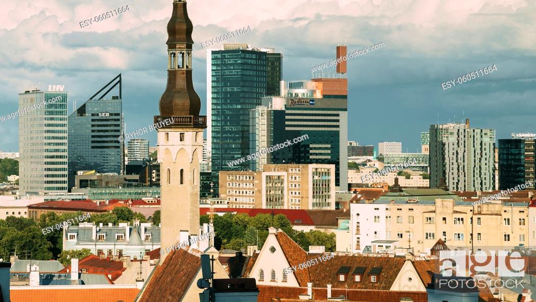 Stock Photo: Tallinn, Estonia. Tower Of Town Hall On Background With Modern Urban Skyscrapers. City Centre Architecture. UNESCO World Heritage Site.
