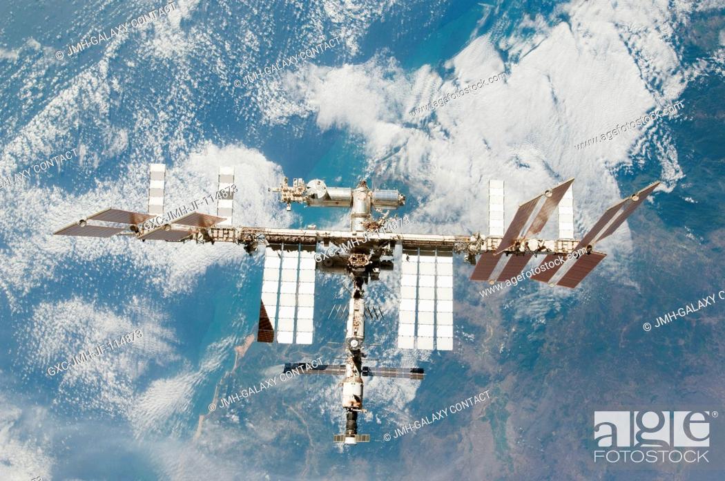 Stock Photo: Backdropped by a colorful part of Earth, the International Space Station is featured in this image photographed by an STS-130 crew member on space shuttle.