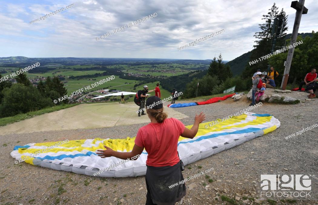 Stock Photo: Pupils of a paragliding school prepare for their examination flight on Buchenberg mountain near Buching, Germany, 30 July 2017.
