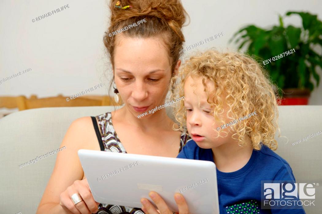 Stock Photo: a blond child and her mom uses a digital tablet.