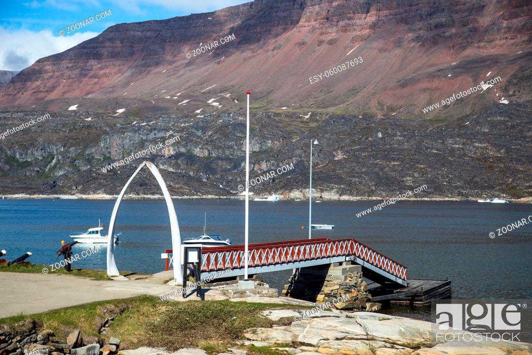 Stock Photo: Qeqertarsuaq, Greenland - July 6, 2018: The jetty at the harbour with bowhead whale jawbone made into arch. Qeqertarsuaq is a port and town located on the south.