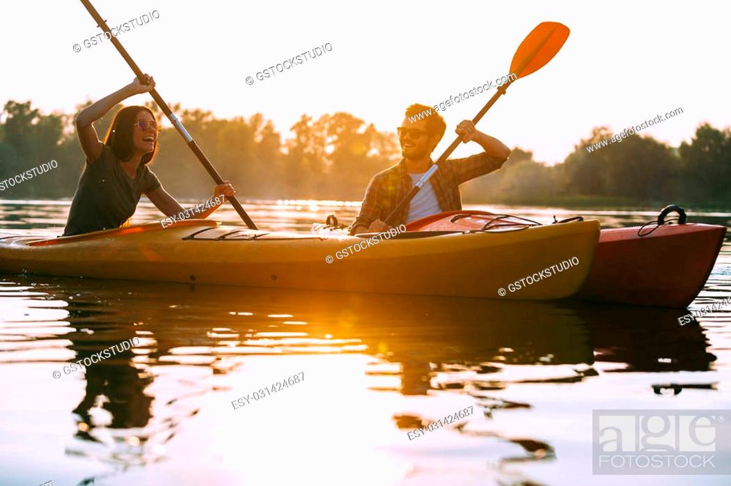 Stock Photo: Kayaking together is fun. Beautiful young couple kayaking on lake together and smiling.