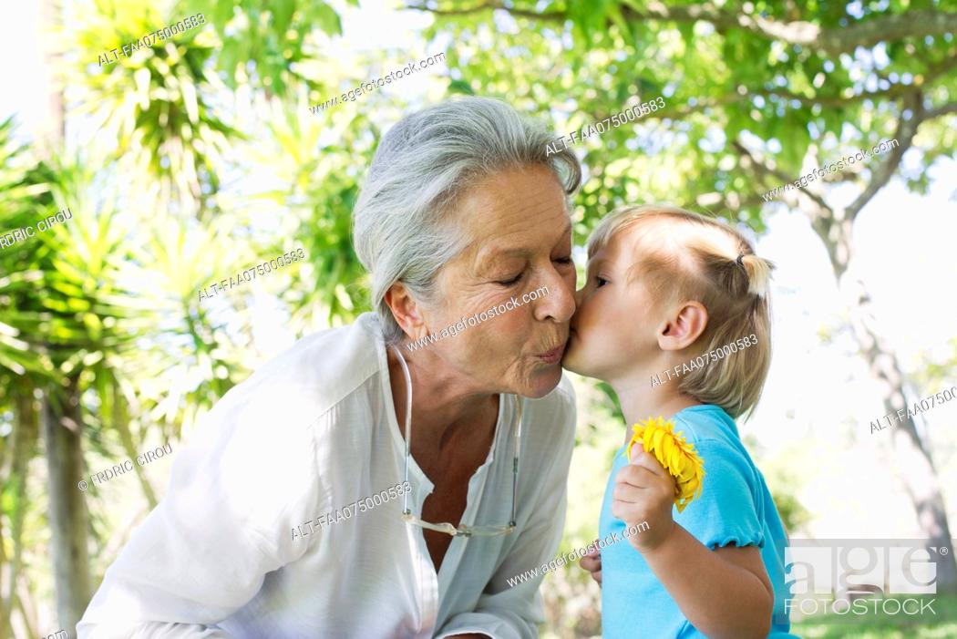 Stock Photo: Little girl kissing grandmother on cheek.