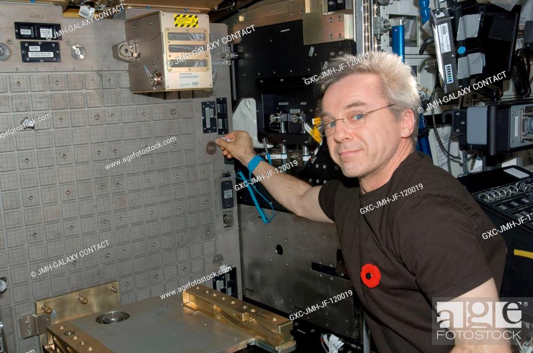 Stock Photo: Canadian Space Agency astronaut Robert Thirsk, Expedition 21 flight engineer, installs the Light Microscopy Module (LMM) Spindle Bracket Assembly in the Fluids.