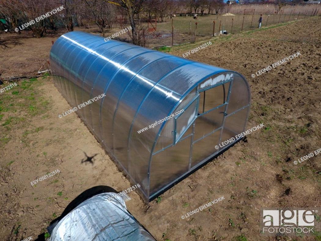 Stock Photo: Polycarbonate greenhouse assembled from parts, prefabricated greenhouse. Greenhouse for vegetables.