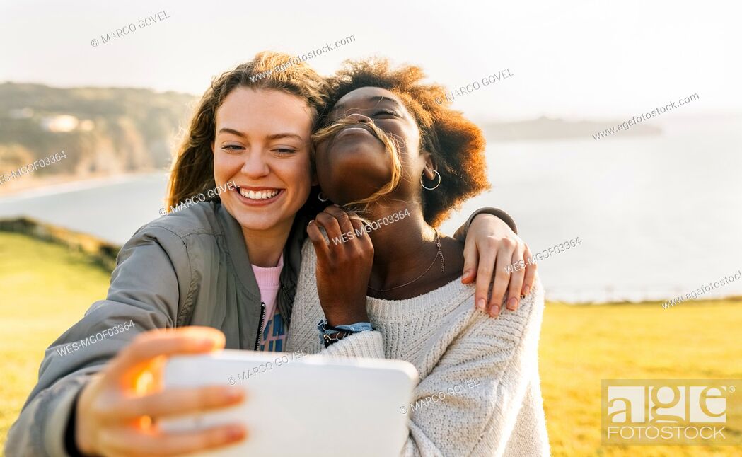 Stock Photo: Two happy best friends making a selfie at the coast.
