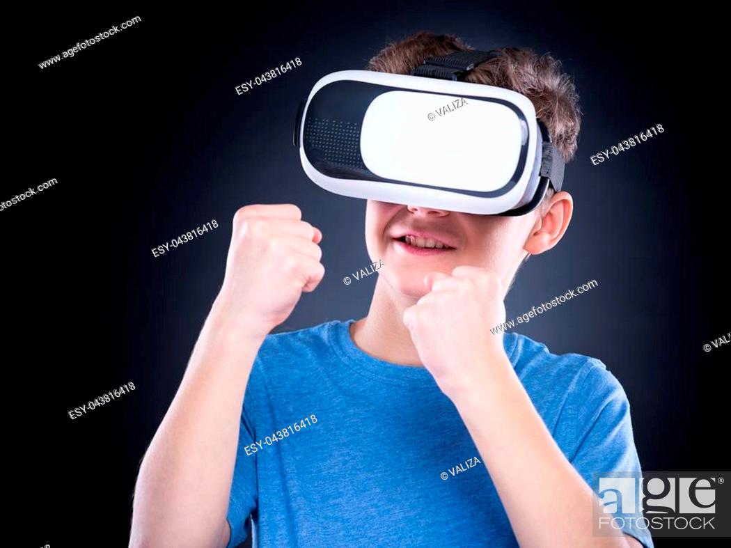 Happy teen boy wearing virtual reality goggles watching movies or playing  video games, Stock Photo, Picture And Low Budget Royalty Free Image. Pic.  ESY-043816418 | agefotostock