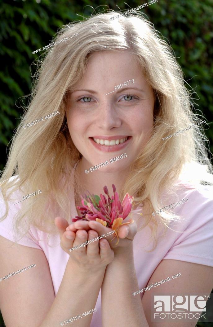Stock Photo: Smiling woman holding honeysuckle.
