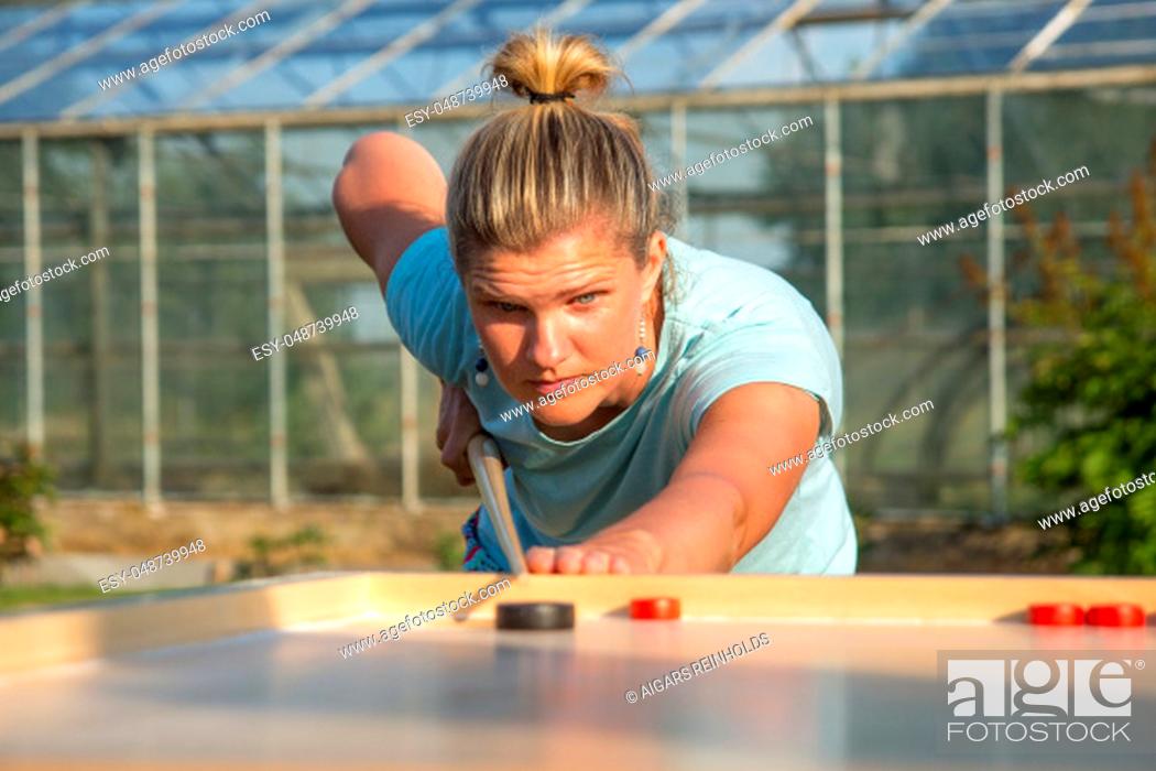 Stock Photo: Women playing Novuss in outdoors. Novuss is a national sport in Latvia similar to pocket billiards or pool.