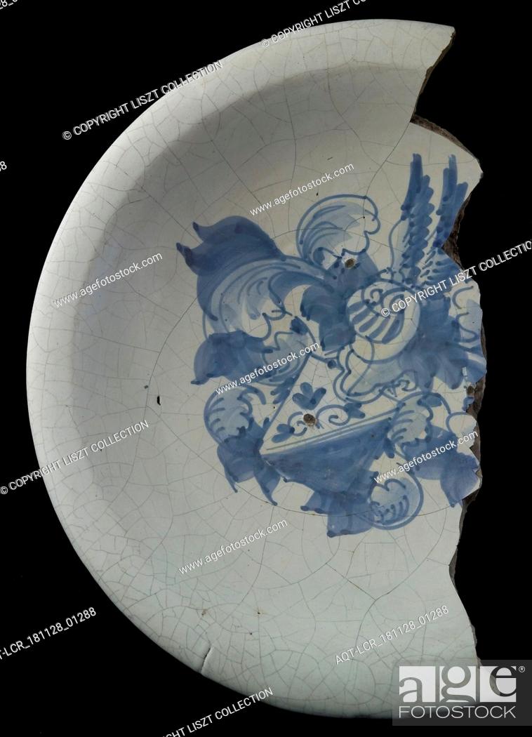 Stock Photo: Fragment majolica dish, blue on white, with heraldic image, helmeted escutcheon with diagonal division, above dark, under light with flora.