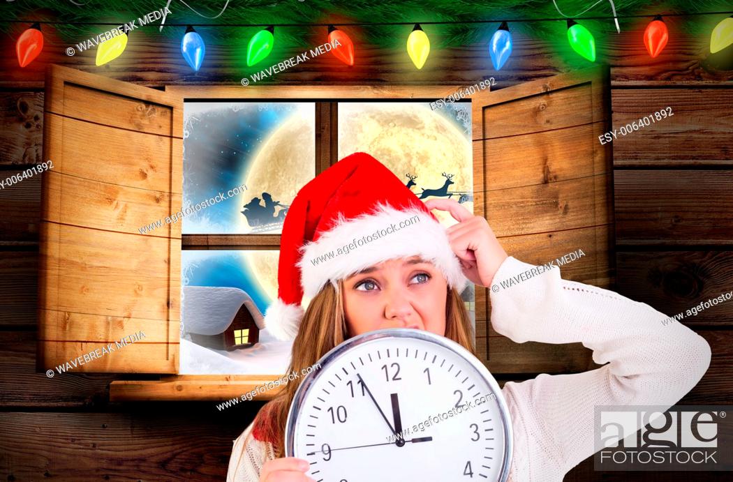 Stock Photo: Composite image of festive blonde showing a clock.