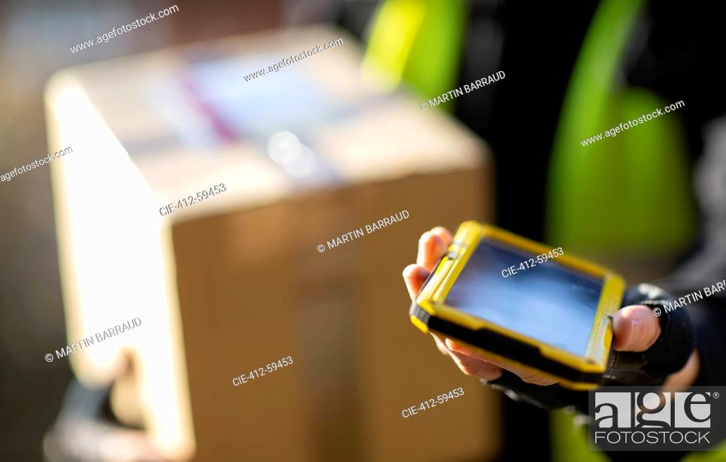 Stock Photo: Close up courier with smart phone delivering package.
