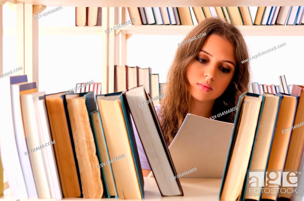 Stock Photo: The young female student preparing for exams at library.