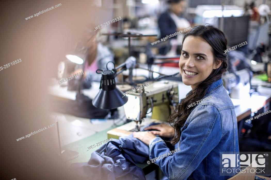 Photo de stock: Seamstress in factory sewing clothes.