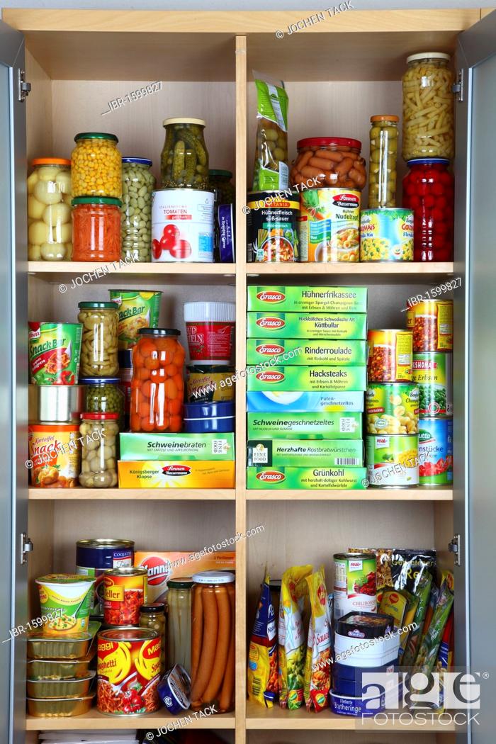 Stock Photo: Cupboard filled with various packaged foods in glass jars and tin cans.