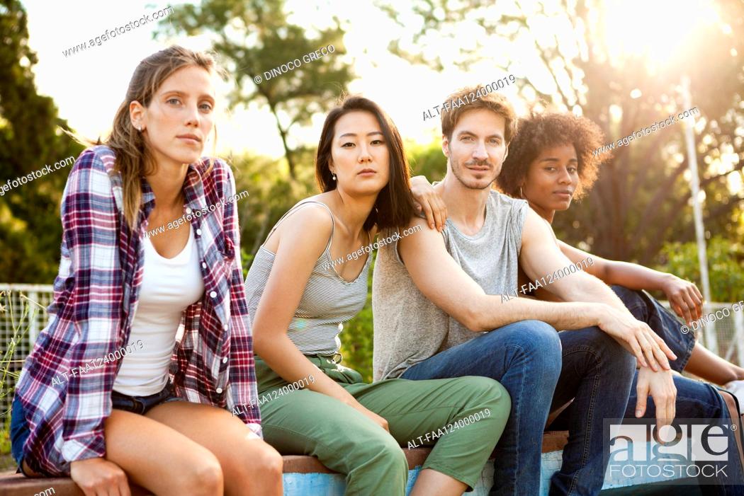 Photo de stock: Group of young friends sitting together in park.