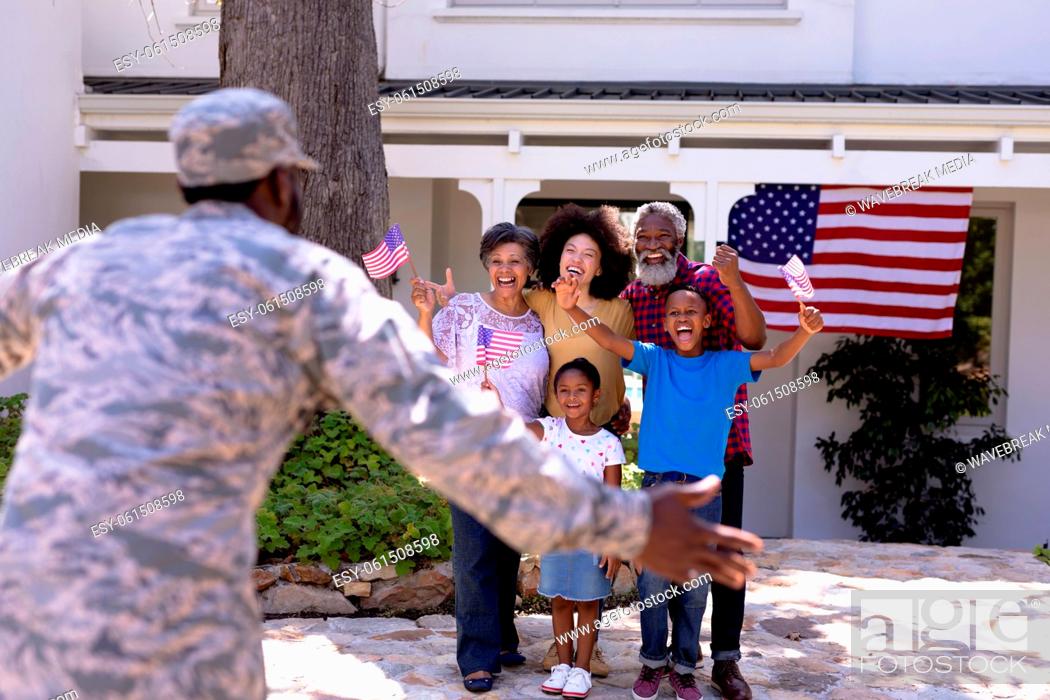 Stock Photo: Multi-generation mixed race family welcoming an African American man wearing military uniform.