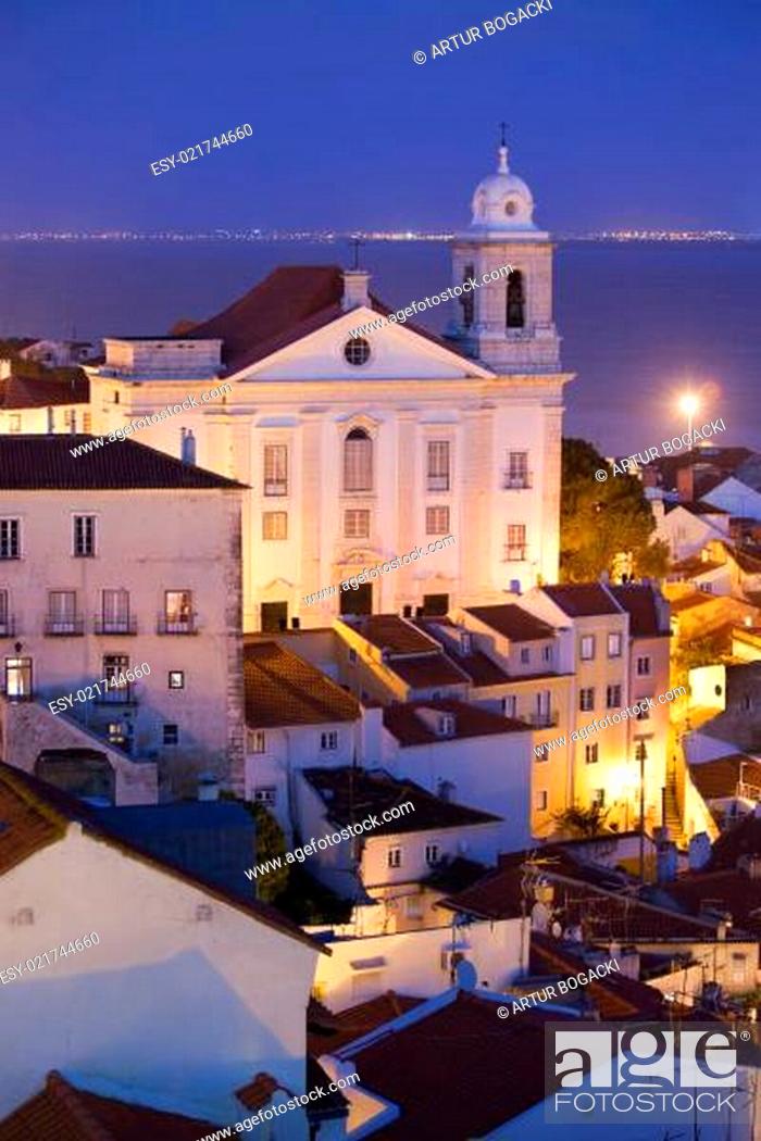 Stock Photo: Santo Estevao Church at night in old city of Lisbon in Portugal, Tagus river in the background.