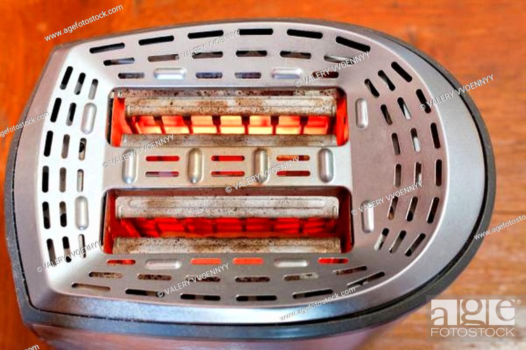 Stock Photo: two slices of bread toasting in metal toaster.