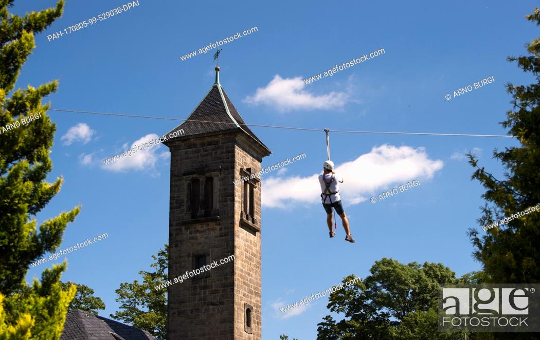 Stock Photo: A man is using the zip line during the ""Festung Aktiv"" outdoor sports festival in Konigstein, Germany, 05 August 2017. The festival offers visitors workshops.