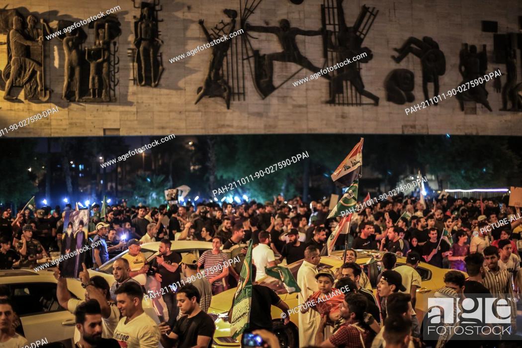 Stock Photo: 11 October 2021, Iraq, Baghdad: Supporters of Iraqi Shiite cleric Moqtada al-Sadr celebrate at Tahrir square following the announcement of parliamentary.