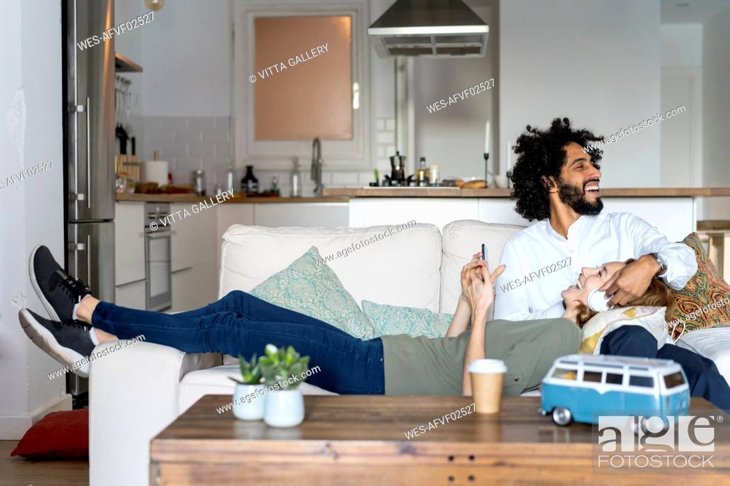 Stock Photo: Couple relaxing on couch, planning their road trip.